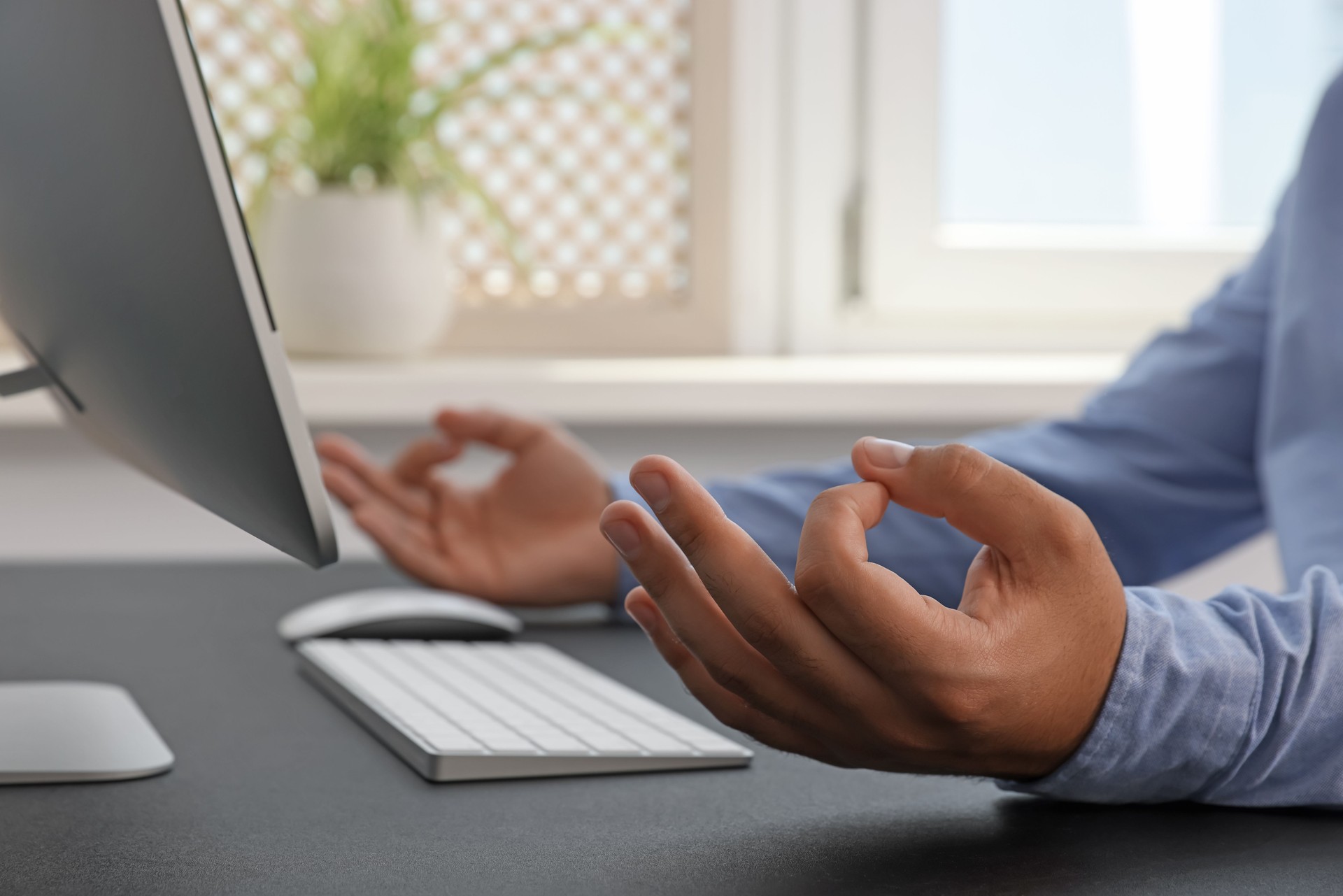 Businessman meditating at workplace, closeup. Zen concept